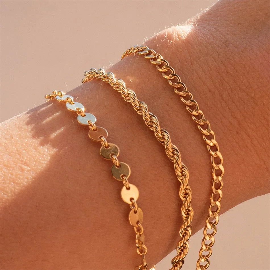 Multiple widths geometric bracelets layered on wrist