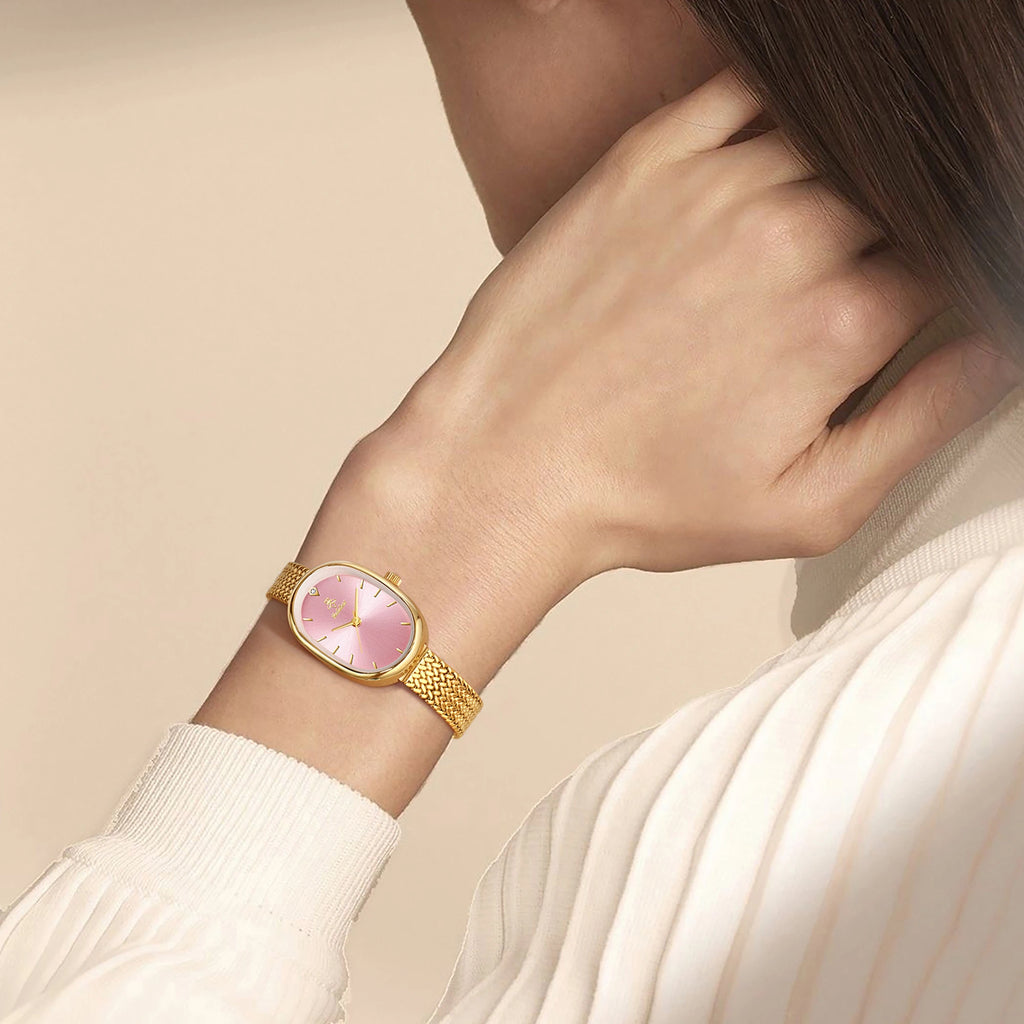 Gold case with pink dial, slim band, numberless face, hook buckle clasp"